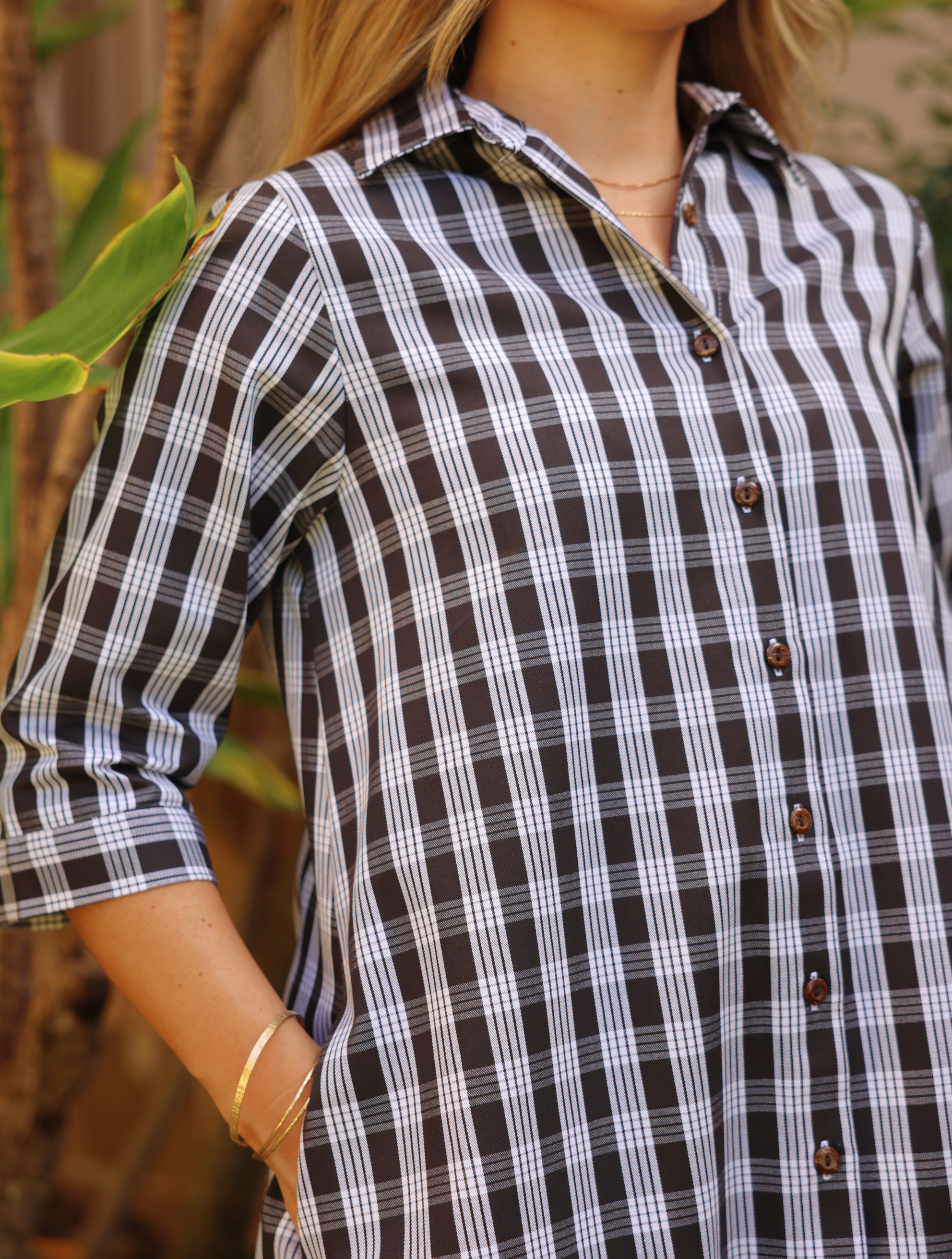 Moana Collection Dress in ʻAʻā tone with traditional Palaka pattern. Model poses with hands in pockets, wearing a thin bracelet.