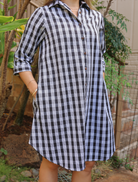 Moana Collection Dress featuring traditional Palaka pattern. Model poses with hands in pockets. Sleeves rolled to elbow.