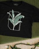 Black crop T-shirt featuring a green leafy design with Palaka print accents, styled against a subtle background.